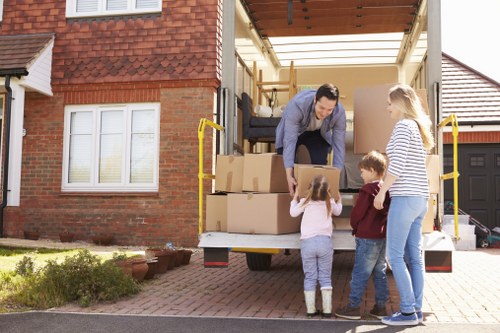 Removal team loading household furniture in West Heath